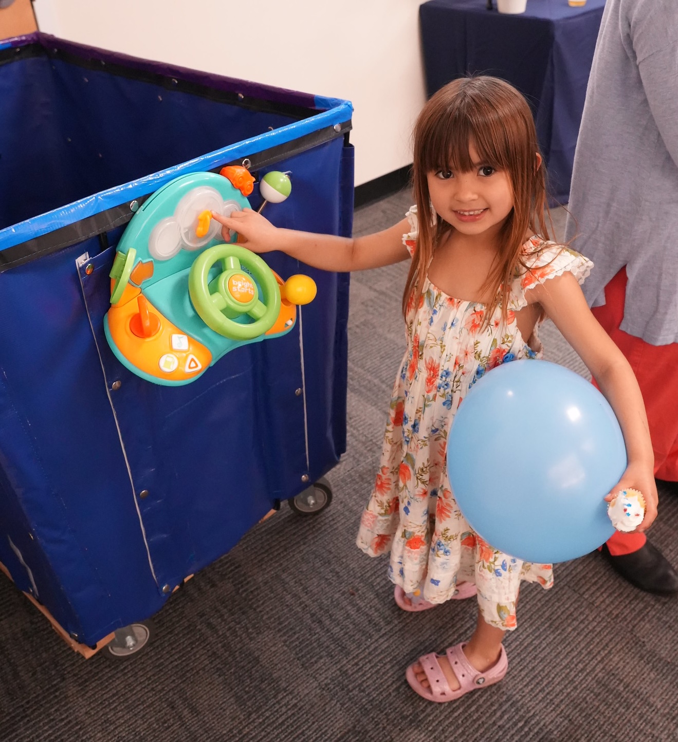 girl drives our donation collection bin with toy steering wheel